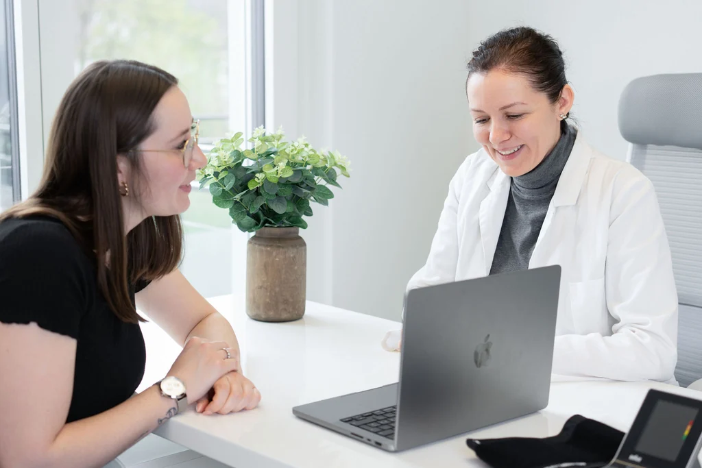 Ärztin bespricht die Befunde mit einer Patientin im Sprechzimmer