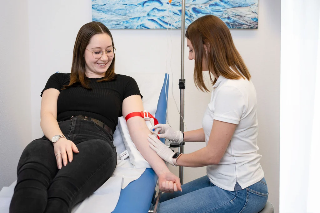 Medizinische Praxisassistentin legt einen Venenzugang für eine Infusion