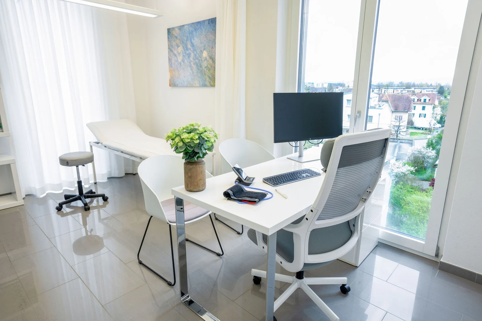 Sprechzimmer mit Untersuchungsliege und Arbeitsplatz